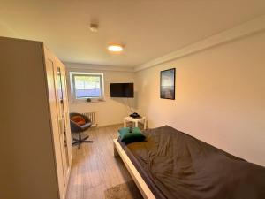 a bedroom with a bed and a chair in it at Weserglück Ferienwohnung Grohnde in Emmerthal