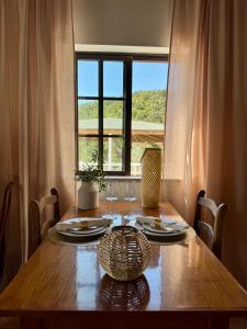 a dining room table with a view of a window at Herdade Da Corte in Tavira
