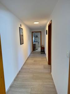a hallway with white walls and a tile floor at Weserglück Ferienwohnung Grohnde in Emmerthal