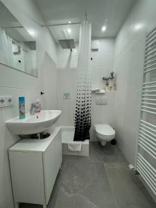 a white bathroom with a sink and a toilet at Tulpen Residenz in Offenbach +25 photos