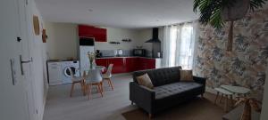 a living room with a couch and a kitchen at Le Petit Nid de Mombrier in Mombrier