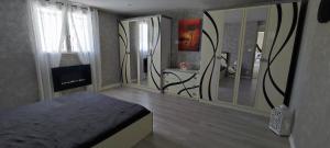 a room with a bed and a tv and a mirror at Le Petit Nid de Mombrier in Mombrier