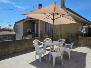 a table and chairs with an umbrella on a patio at Casa Bonaria in Terralba