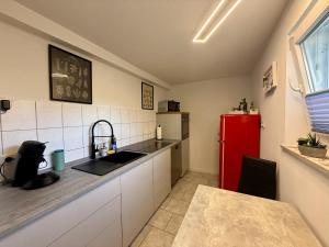 a kitchen with a sink and a red refrigerator at Weserglück Ferienwohnung Grohnde in Emmerthal