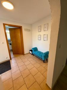 a living room with a blue couch and a door at Weserglück Ferienwohnung Grohnde in Emmerthal +2 photos