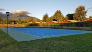 a tennis court with a mountain in the background at Casa Pucon in Pucón