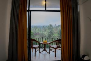 a room with a balcony with a table and chairs at Ivory Canopy Resort - Ella in Ella