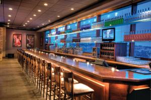 a bar with chairs and a long bar counter at Harrah's Council Bluffs Hotel & Casino - A Caesars Rewards Destination in Council Bluffs