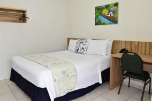 a small bedroom with a bed and a chair at CR Hotel Bueno in Goiânia +95 photos