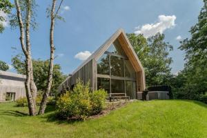 a house with a triangular roof and large windows at Lodge with Jacuzzi | 6 persons in Heusden - Zolder