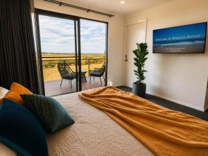 a bedroom with a large bed and a large window at Boutique Room - Wamoon Retreat in Yanakie