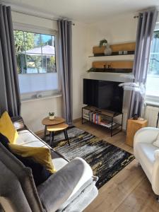 a living room with a couch and a tv at DAS kleine Haus in Wandlitz