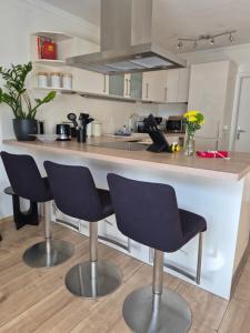 a kitchen with two bar stools and a counter at DAS kleine Haus in Wandlitz
