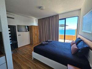 a bedroom with a bed with a view of the ocean at Beachfront Blue Panorama in Bar