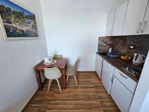 a small kitchen with a wooden table and a table and chairs at Beachfront Blue Panorama in Bar +20 photos