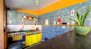 a kitchen with a yellow and blue tiled wall at Bella vida Geriba suites in Búzios
