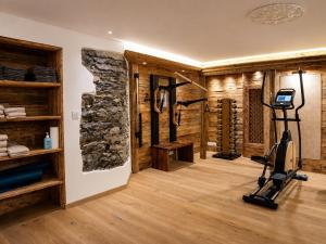 a fitness room with a stone wall and a gym at Villa Flora 1909 - Private Alpine Residence in Grindelwald