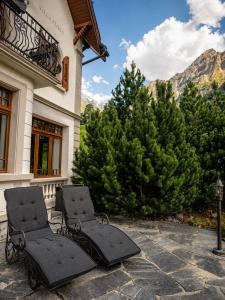 two chairs on a patio in front of a building at Villa Flora 1909 - Private Alpine Residence in Grindelwald