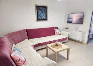 a living room with a purple couch and a table at Alpha Casa in Bar