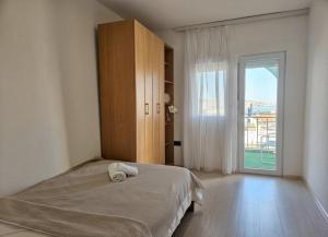 a bedroom with a bed and a large window at Alpha Casa in Bar