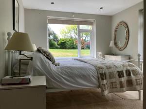 a bedroom with a bed and a large window at Phoenix Cottage in Kippford