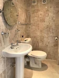 a bathroom with a sink and a toilet and a mirror at Phoenix Cottage in Kippford +28 photos