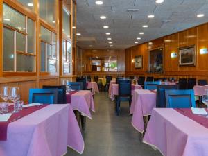 a dining room with pink tables and blue chairs at El 9 Baral-la in Sant Pau de Segúries