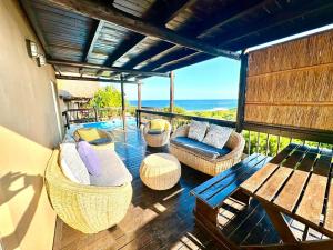 a balcony with wicker chairs and a table and the ocean at Athule Inn - Mozambique in Chidenguele