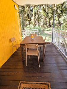 a wooden table and chairs on a porch at Le Ghirol - Tiny Houses & Nature in Quesnel