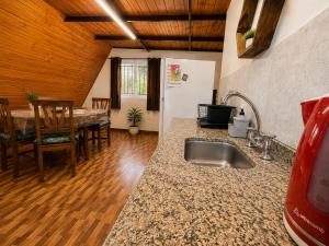 a kitchen and dining room with a sink and a table at Cabañas Caranday in Capilla del Monte +13 photos