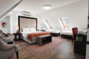 a bedroom with a bed and a couch and a chair at Hotel Ottofiori in Budapest