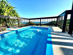 a swimming pool on a balcony with the ocean in the background at Athule Inn - Mozambique in Chidenguele