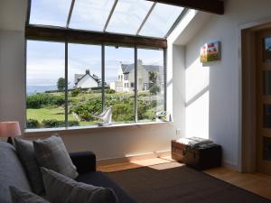 a living room with a large window and a couch at Hollinhaven in Blackwaterfoot