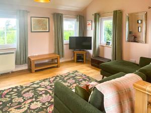 a living room with a couch and a tv at Hollinhaven in Blackwaterfoot