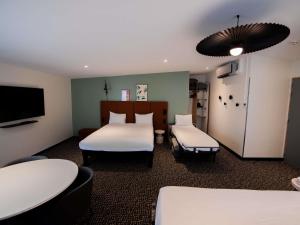 a hotel room with two beds and a tv at ibis Paris Canal Saint Martin in Paris
