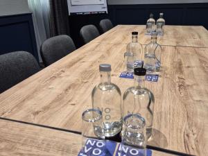a group of wine bottles and glasses on a wooden table at Novotel Manchester West in Worsley