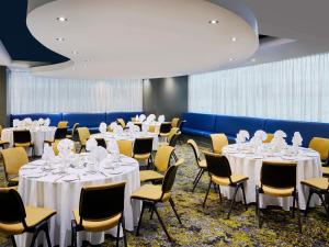 a conference room with tables and chairs with white table settings at Novotel Toronto North York in Toronto +106 photos