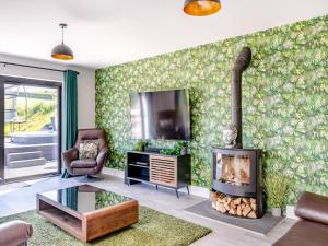 a living room with a fireplace and a tv at The Black Barn in Marldon
