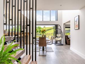a dining room with a table and chairs and a large window at The Black Barn in Marldon