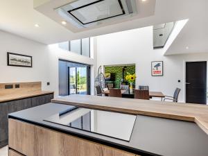 an open kitchen with a large island in a house at The Black Barn in Marldon