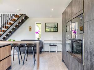 a kitchen and dining room with a table and a staircase at The Black Barn in Marldon +21 photos