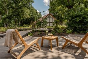 two chairs and a table on a patio at Accessible Luxury Suite for 2 – Woodz Lodges in Heusden - Zolder
