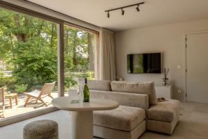 a living room with a couch and a table at Accessible Luxury Suite for 2 – Woodz Lodges in Heusden - Zolder