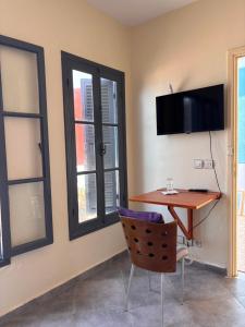 a room with a desk and a chair and windows at Maison Sevilla in Larache