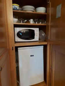 a microwave sitting on top of a refrigerator in a kitchen at Chambres vertes in Bouchamps-lès-Craon