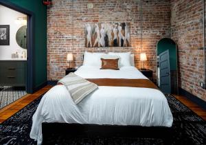 a bedroom with a large bed with a brick wall at Best Intentions in Port Clinton