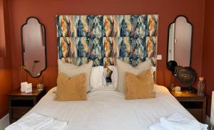 a bedroom with a large white bed with a large headboard at The Red Lion in Blewbury