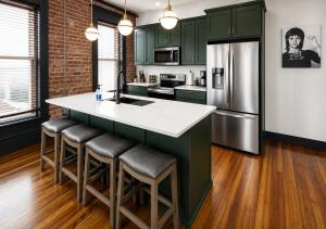a kitchen with green cabinets and a kitchen island with bar stools at Best Intentions in Port Clinton +7 photos