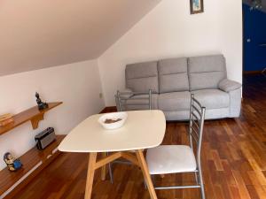 a living room with a table and a couch at Yellow Attic in Senhora do Rosário
