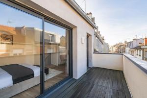 a bedroom with a bed on a balcony at MM Suites Town House Terrasse in Reims
